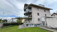 3 story building, balconies, large windows, garden, tennis court
