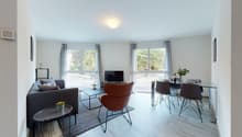 Living room and dinning area, hardwood floor, large windows, coffee table, sofa, chair, TV, desk