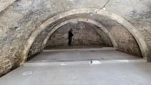 Arched ceiling, stone walls, white tile flooring, in-progress electrical wiring, arch-shaped doorways.