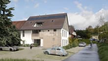 Modern house with solar panels, white exterior, brown roof, driveway with cars, person on bicycle, trees, and greenery.