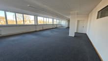 large room with glass windows, white ceiling, gray carpet, fluorescent lighting