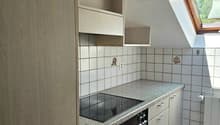 Compact kitchen with built-in cabinets, granite countertop, tiled backsplash, and a built-in oven and stovetop. The kitchen also features a dishwasher.