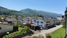 detached houses, residential neighborhood, detached garages, trees, mountainous background