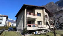 3 story house, beige exterior, red roof, balcony, car parked in front