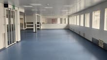 empty, large room, blue floor, white walls, large windows, ceiling lights