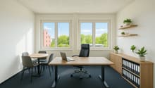 Spacious office with large windows providing a view of the surrounding greenery, a wooden desk with a laptop, chairs, and shelves with plants and office supplies.