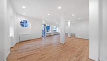 empty room, wooden floor, white walls, round window, glass door, radiators