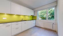 modern kitchen with white cabinets, yellow backsplash, granite countertop, stainless steel sink, faucet, large window with view of trees