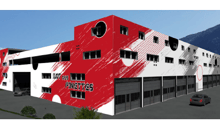 Industrial building, red and white facade, multiple garages, car entrance