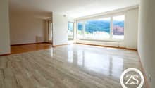 large room with marble flooring, white walls, sliding glass doors, large windows with view, underfloor heating