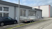 grey building with sign AMAVIS, 3 cars parked in front