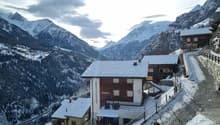 Mountain lodge house, wood paneling, covered terrace, snow on roof, balcony