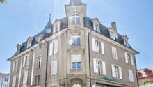 Elegant facade, multiple windows, central entrance, terrace with outdoor seating