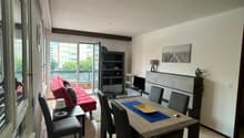 open space living room with large windows, balcony access, dining table, sofa, TV stand, floor lamp
