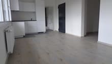 Modern kitchen with white cabinets, countertops, tiled floor, radiator, and faucet