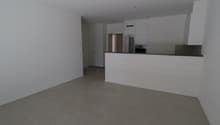 Empty room, tiled floor, kitchen, white walls and ceiling, cupboards, countertop