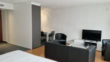 living room with sofa, armchairs, coffee table, desk, chairs, TV, lamp, tiled floor