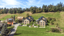 3 detached houses, each with 4 stories, surrounded by a well-maintained lawn and trees