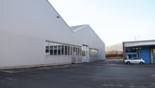metal siding, large windows, adjacent smaller building, empty parking lot