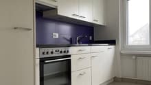 kitchen with white cabinets, blue backsplash, electric stove, oven, sink with faucet, tile flooring