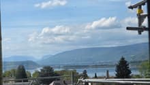 View of a lake and mountains from a balcony with construction scaffolding