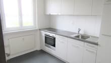 modern kitchen with white cabinets, stainless steel appliances, granite countertop, large window