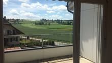 sliding glass door, balcony, metal railing, tiled floor, view of a green field