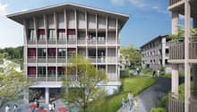 Modern apartment building with multiple balconies, large windows, and a central courtyard.