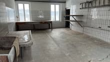 empty room, white tiles, concrete floor, wooden table, sink, ladder, 2 windows