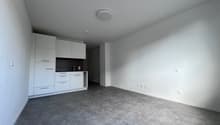 empty room with gray floors, white walls, built-in cabinets, and electrical outlets