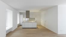Open kitchen, white cabinets, wooden floor, white walls, central island, modern design