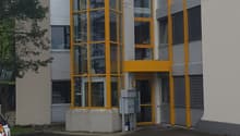 Two story office building with glass wall and entrance