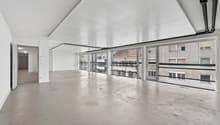 Spacious, clean, white walls, concrete floor, open doors, glass walls, balconies