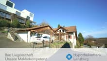 2 story house, brown roof, white walls, garage, car parked in front