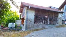 Detached house, brick walls, terracotta roof, closed wooden door, parking area, water tank on the left