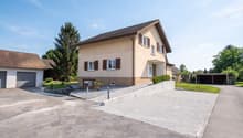 2 story house, brown roof, beige walls, 2 garages, driveway, mailbox