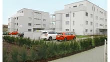 Two story white residential buildings, several parked cars, bushes