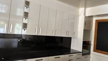 White cabinets, black countertops, gas stove, built-in oven, pull-out shelves, drawers with silver handles, modern design