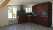 kitchen, maroon cabinets, gray tile backsplash, wooden floor, exhaust hood, stainless steel oven, white radiator