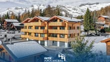 3-story building, wooden exterior, balconies, snowy mountains in the background