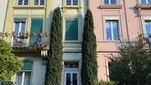3 story house, balcony, green shutters, white door, plants and trees