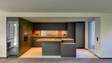 modern kitchen with island, gray cabinets, wooden countertops, built-in appliances, large windows
