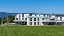 modern white building, balconies, garden, wide field in front