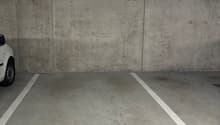 A concrete parking area with two white-marked parking spaces, marked with number '24' and empty