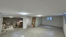 empty room with a ceiling and lights, a small white pillar, ladders and tools
