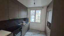 modern kitchen with black and grey colors, electric stove, sink, cabinets, marbled flooring