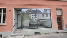 Pink building with glass entrance, steps leading up, large glass windows, number 10 on the door