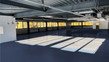 empty room, steel ceiling, blue floor, large windows, sunlight