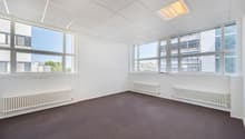 Office: empty room, white walls, white ceiling, grey carpet, windows, two white radiators