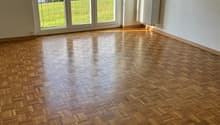 empty room, wooden parquet floor, sliding glass doors, balcony, radiator